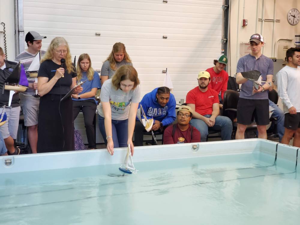 Students look on as a student launches her boat